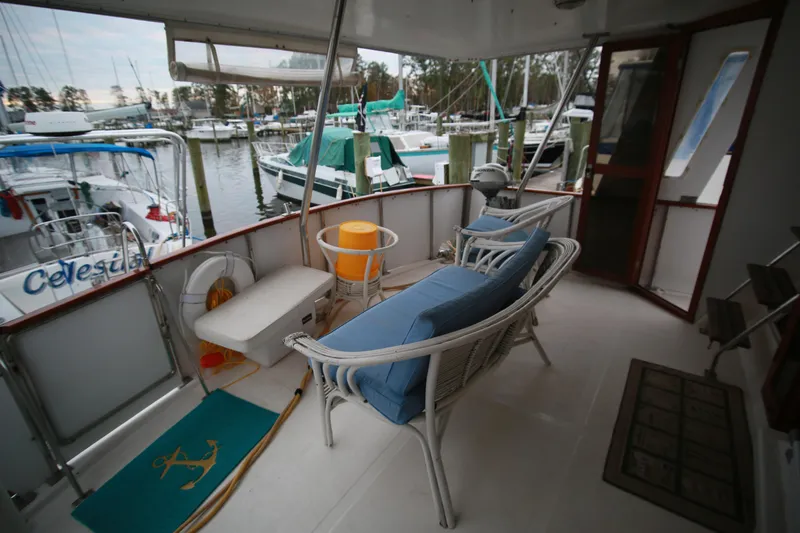 Slide: The Image of 1987 Jefferson 42 Sundeck Motor Yacht deck with seating and marina view. - 44