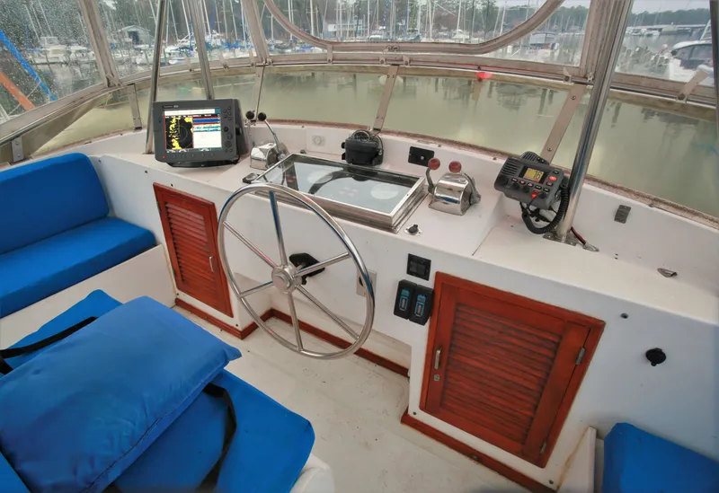 Slide: The Image of 1987 Jefferson 42 Sundeck Motor Yacht helm with navigation equipment and blue seating. - 6