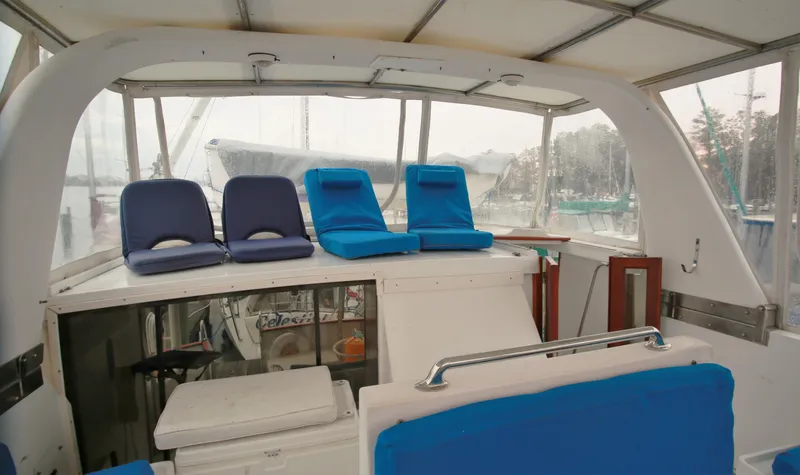 Slide: The Image of 1987 Jefferson 42 Sundeck Motor Yacht interior with blue seating and covered deck. - 7