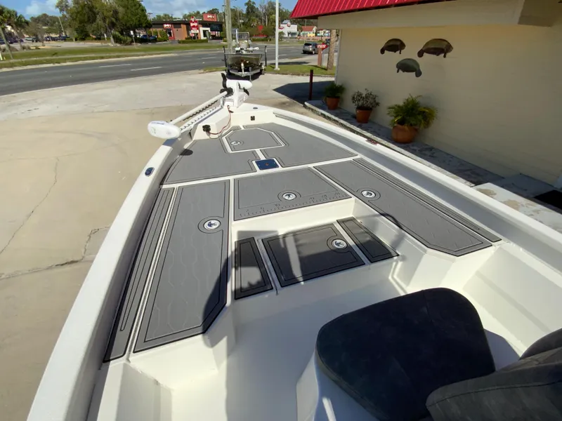 Slide: The Image of 2023 Avid 21 Mag boat with gray deck, docked near a building. - 7