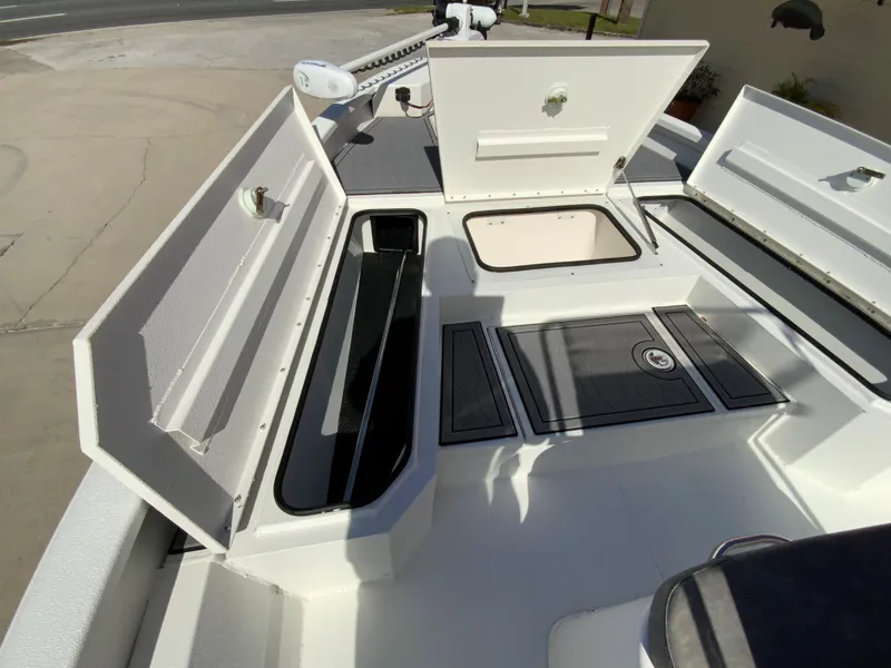 Slide: The Image of 2023 Avid 21 Mag boat with open storage compartments and deck view. - 8