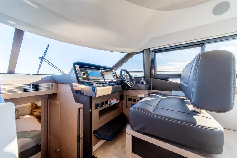 Slide: The Image of 2024 Prestige 460 yacht interior helm station with modern controls and leather seating. - 10