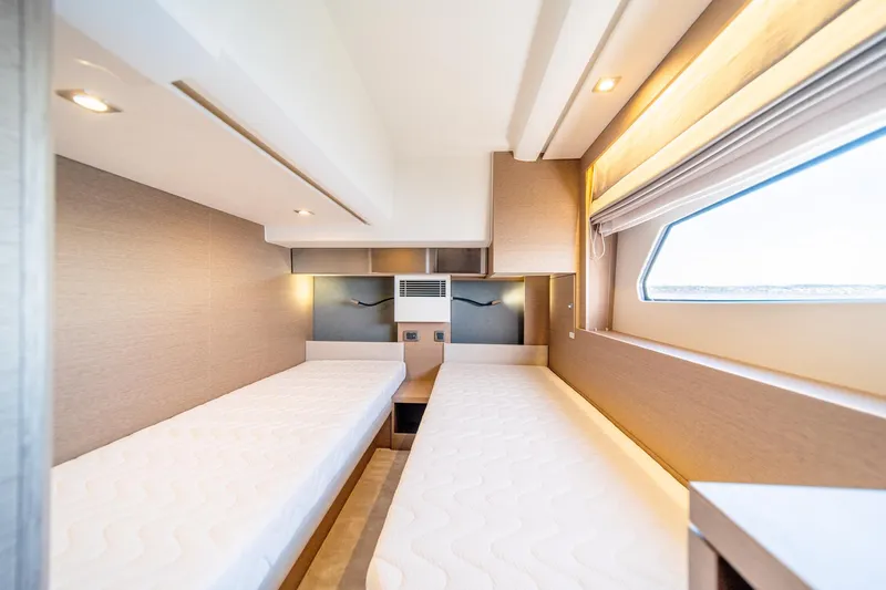 Slide: The Image of 2024 Prestige 460 yacht interior cabin with twin beds and window. - 20