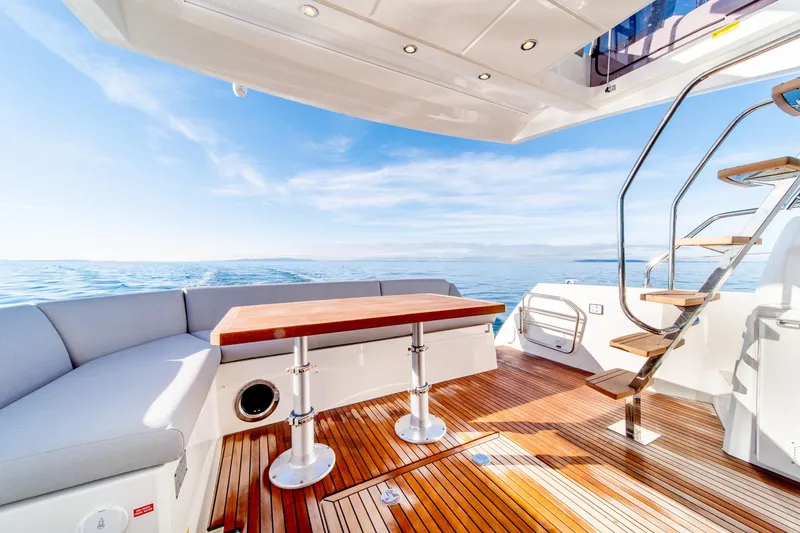 Slide: The Image of Prestige 460 yacht 2024 model, luxurious deck with seating and ocean view. - 22