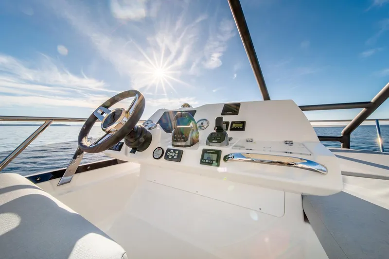 Slide: The Image of Prestige 460 2024 yacht helm station with ocean view and bright sun. - 24
