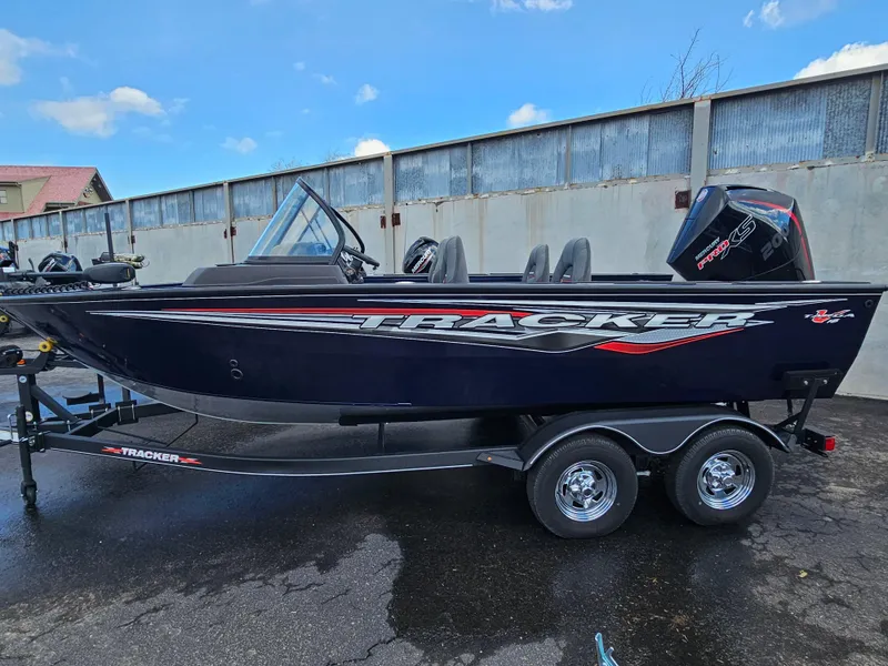 The Image of 2023 Tracker Targa V-18 WT fishing boat on trailer, black with red accents. - 0