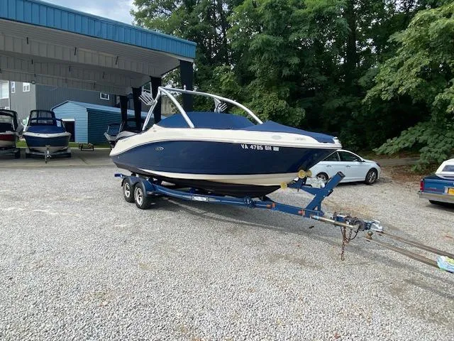 Slide: The Image of 2008 Sea Ray 230 Select Fission boat on a trailer in a marina. - 17