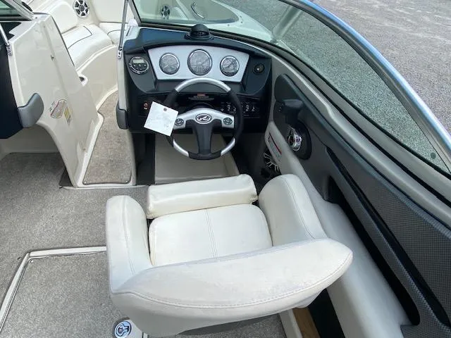 Slide: The Image of 2008 Sea Ray 230 Select Fission boat cockpit with steering wheel and white captain's chair. - 24