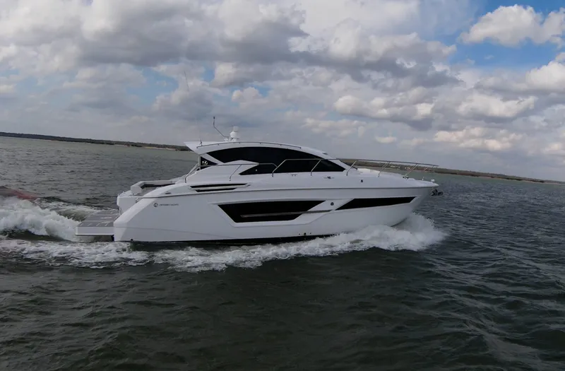 Slide: The Image of 2020 Cruisers Yachts 460 Cantius cruising on open water under a cloudy sky. - 10
