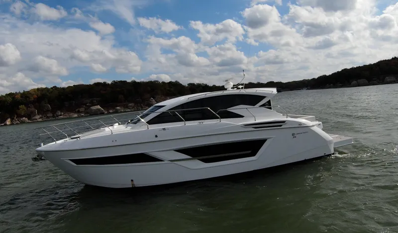 Slide: The Image of 2020 Cruisers Yachts 460 Cantius on a lake with a scenic background. - 14