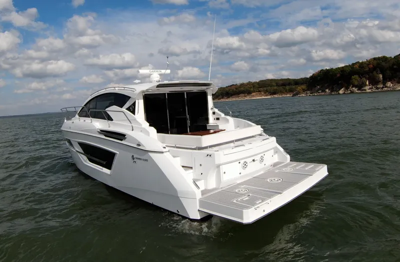 Slide: The Image of 2020 Cruisers Yachts 460 Cantius on open water with scenic shoreline. - 16