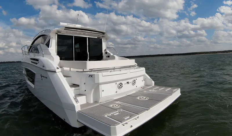 Slide: The Image of 2020 Cruisers Yachts 460 Cantius on open water under a partly cloudy sky. - 17