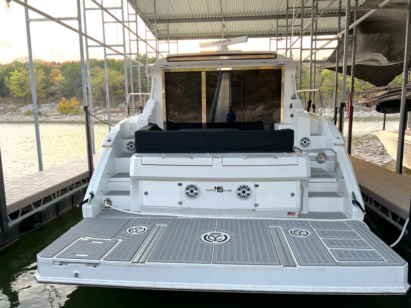 Slide: The Image of 2020 Cruisers Yachts 460 Cantius docked, rear view showing spacious deck and seating area. - 24