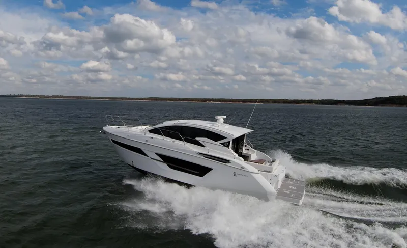 Slide: The Image of 2020 Cruisers Yachts 460 Cantius cruising on open water under a partly cloudy sky. - 3