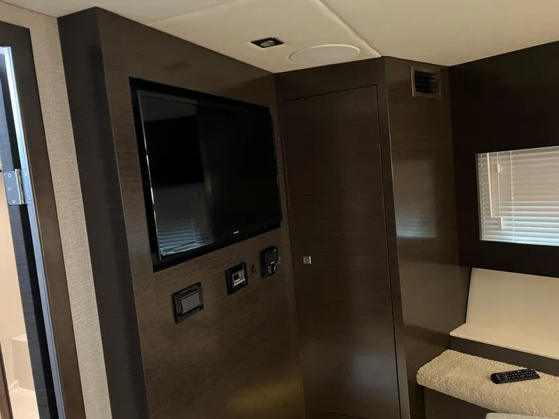 Slide: The Image of 2020 Cruisers Yachts 460 Cantius interior with TV, dark wood paneling, and modern design. - 37