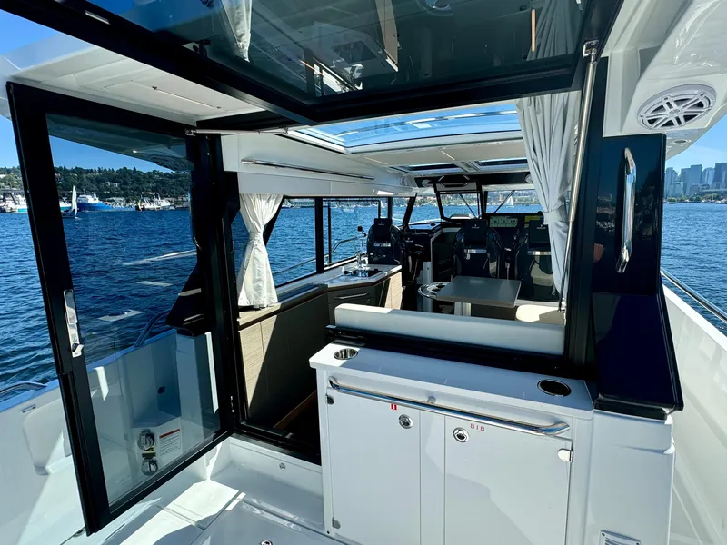 Slide: The Image of 2024 Wellcraft 355 boat interior with open glass doors and scenic water view. - 14