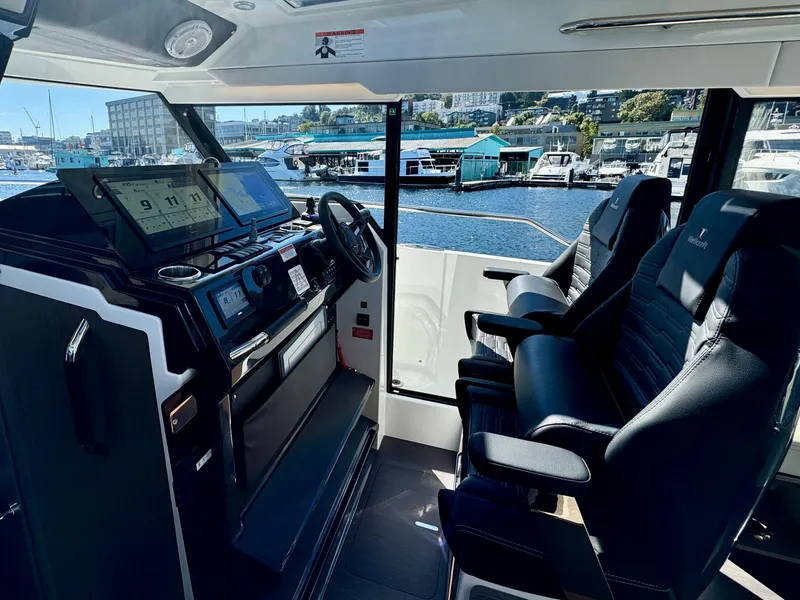 Slide: The Image of 2024 Wellcraft 355 boat interior with modern dashboard and seating, overlooking marina. - 18