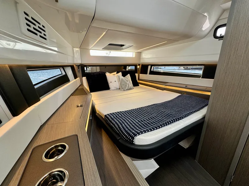 Slide: The Image of 2024 Wellcraft 355 cabin interior with modern design and cozy bedding. - 20