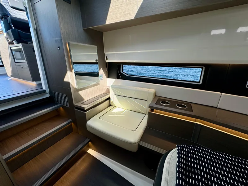 Slide: The Image of 2024 Wellcraft 355 yacht interior with modern seating and ocean view window. - 22