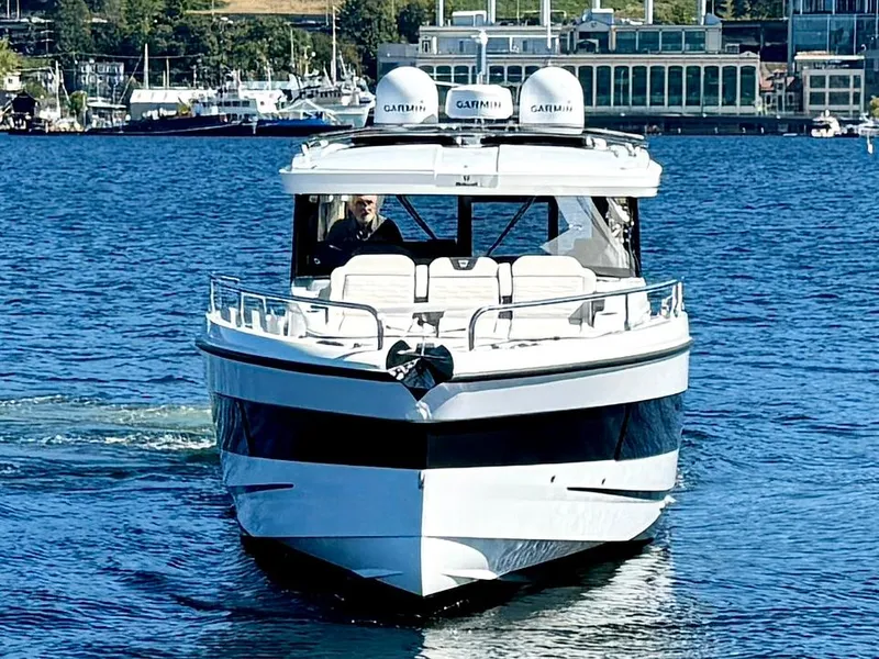 Slide: The Image of 2024 Wellcraft 355 boat cruising on a sunny day in a harbor. - 3
