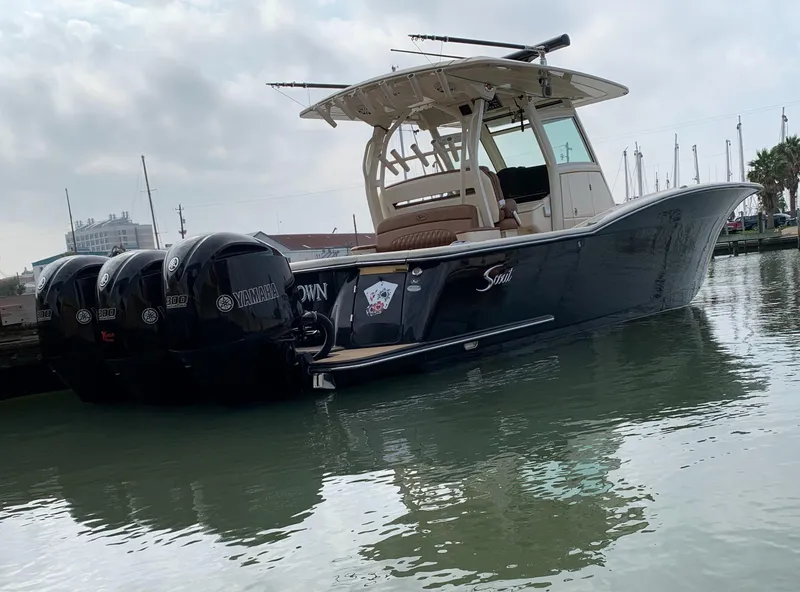 The Image of 2018 Scout 350 LXF boat with triple Yamaha engines docked in marina. - 0