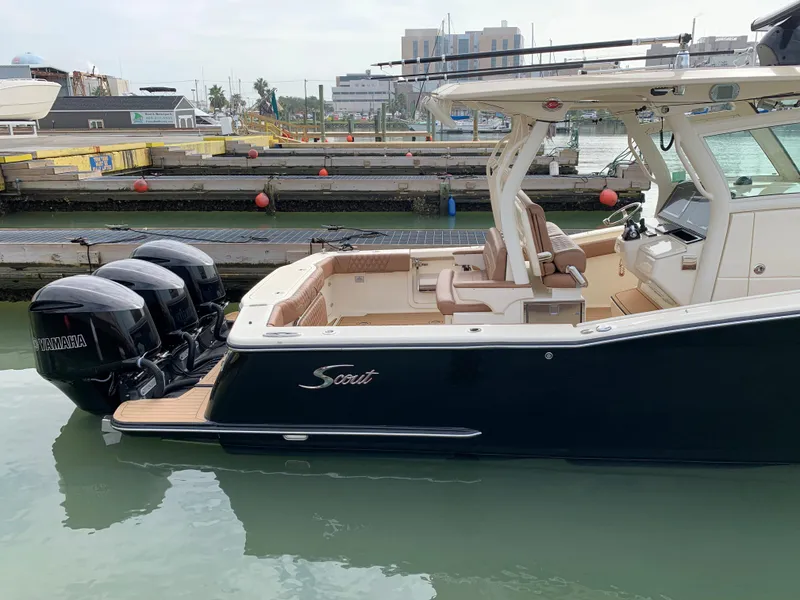 Slide: The Image of 2018 Scout 350 LXF boat docked, featuring triple Yamaha outboard engines. - 10