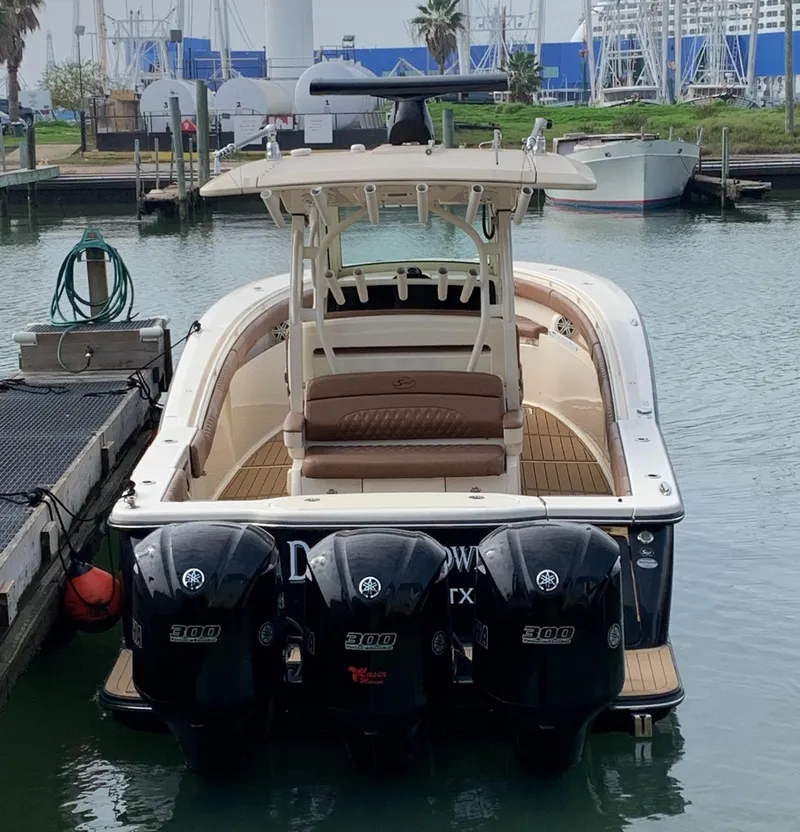 Slide: The Image of 2018 Scout 350 LXF boat docked with triple outboard engines. - 11