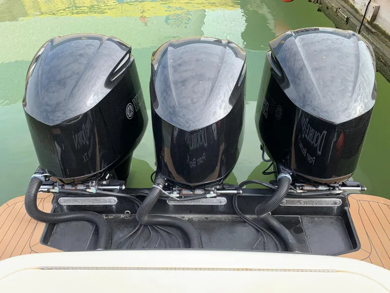 Slide: The Image of Triple outboard engines on a 2018 Scout 350 LXF boat, docked in water. - 12