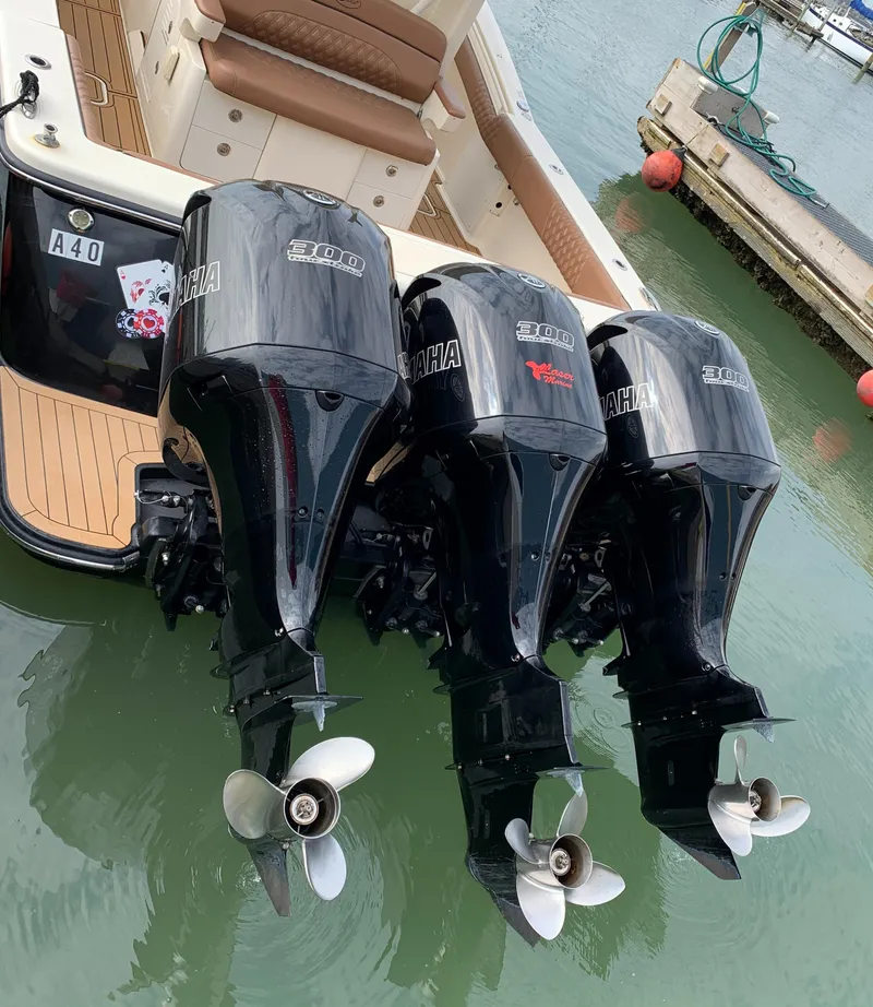 Slide: The Image of 2018 Scout 350 LXF boat with triple Yamaha outboard engines docked in marina. - 13