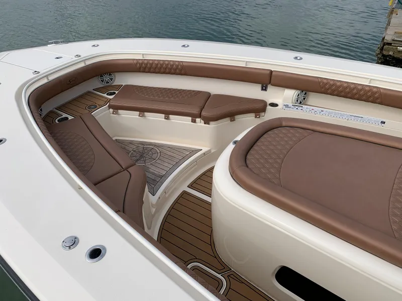 Slide: The Image of 2018 Scout 350 LXF boat interior with brown leather seating and wood flooring. - 20