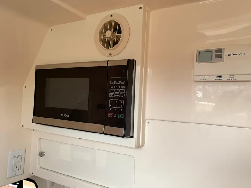 Slide: The Image of Microwave and control panel inside 2018 Scout 350 LXF boat cabin. - 22