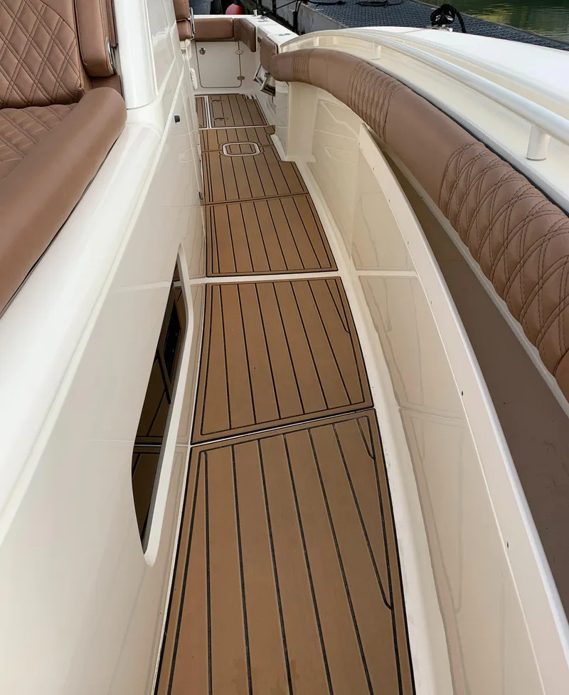 Slide: The Image of 2018 Scout 350 LXF boat deck with brown cushioned seating and teak flooring. - 30