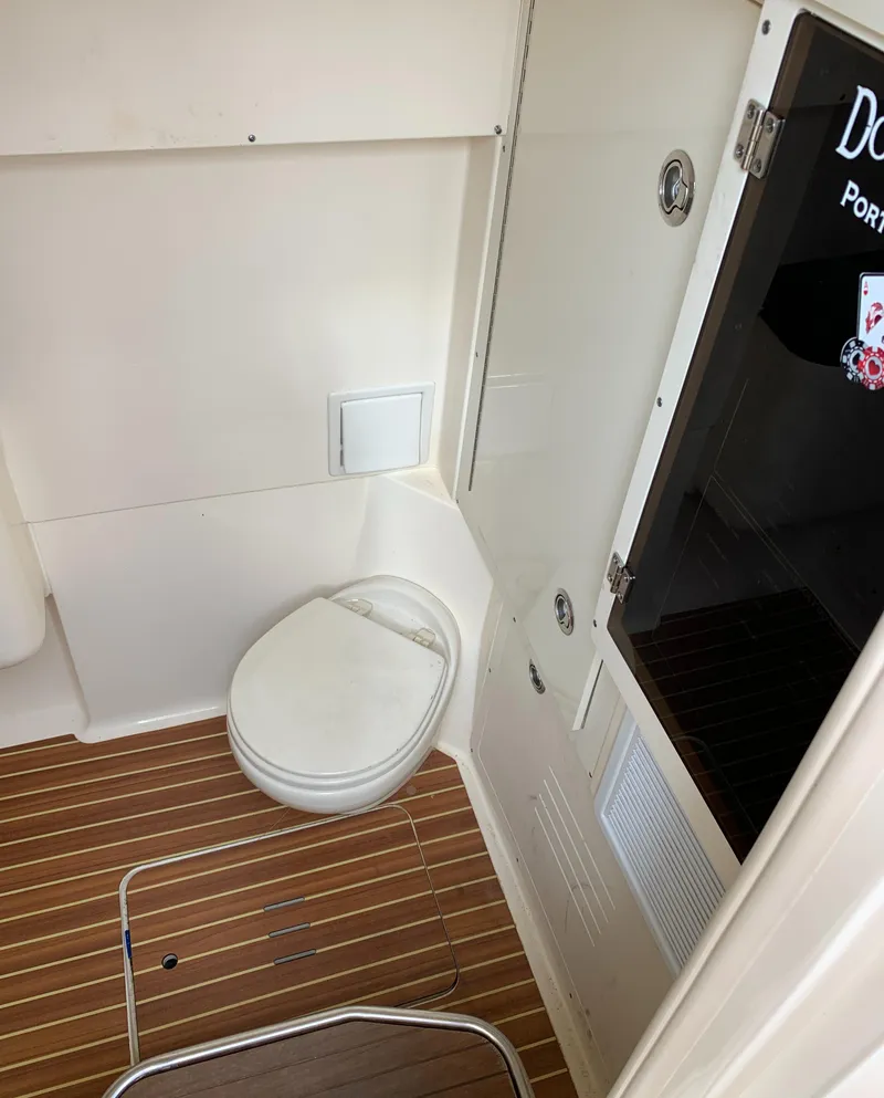 Slide: The Image of 2018 Scout 350 LXF boat interior with compact marine toilet and wooden flooring. - 33