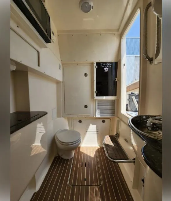 Slide: The Image of 2018 Scout 350 LXF boat interior with toilet, sink, and wooden flooring. - 36