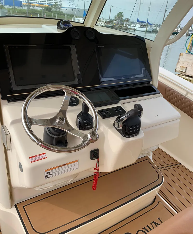 Slide: The Image of 2018 Scout 350 LXF boat helm with dual screens and steering wheel. - 38