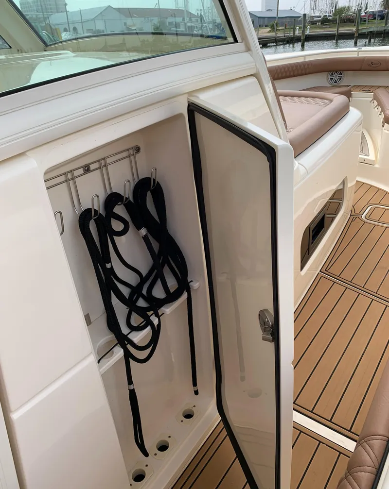Slide: The Image of 2018 Scout 350 LXF boat interior with open storage compartment and coiled ropes. - 40