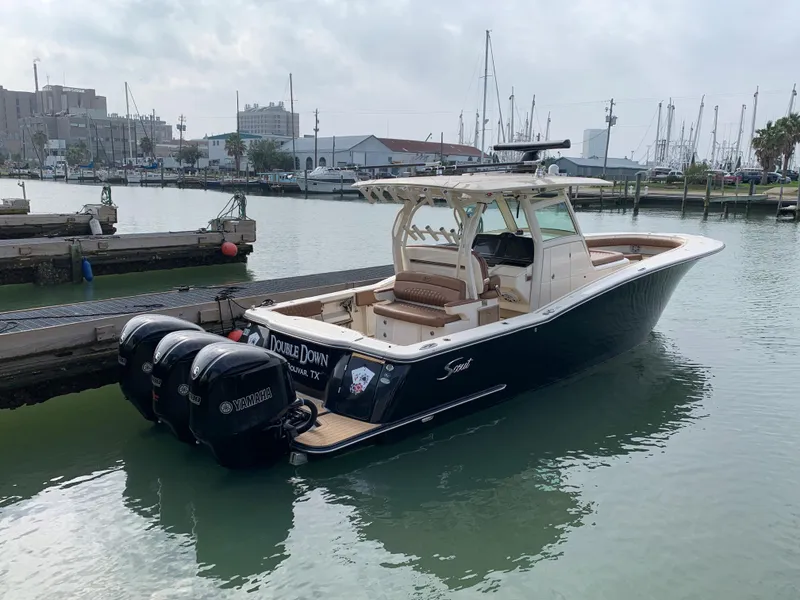 Slide: The Image of 2018 Scout 350 LXF boat docked in a marina with triple outboard engines. - 5