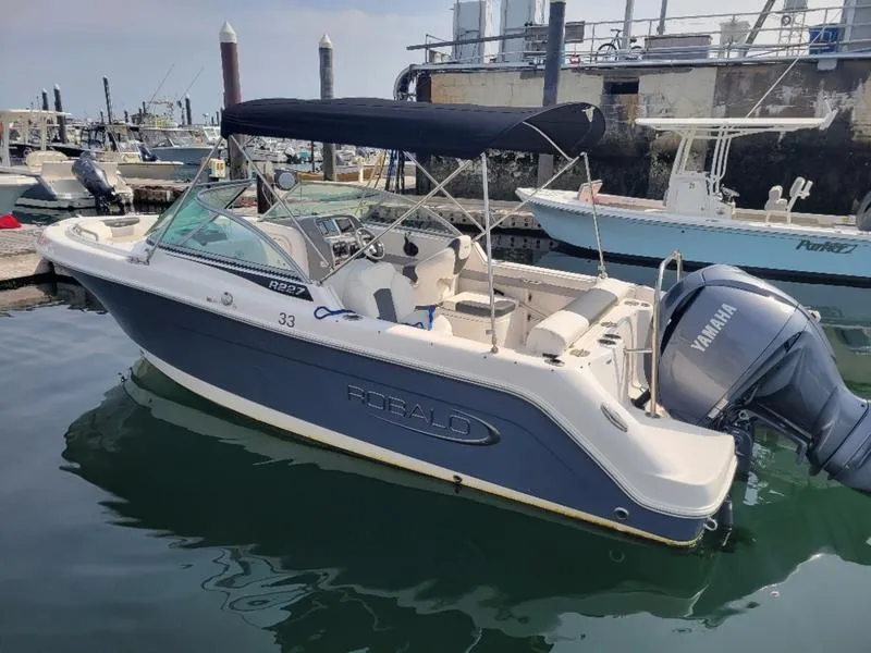 Slide: The Image of 2023 Robalo 227 DC boat docked with Yamaha outboard engine. - 11