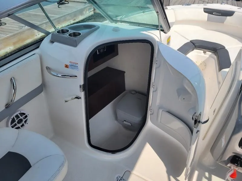 Slide: The Image of 2023 Robalo 227 DC boat interior with open cabin door and seating area. - 5