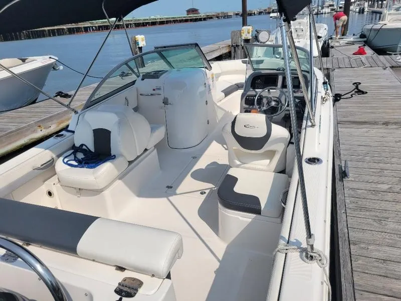 Slide: The Image of 2023 Robalo 227 DC boat docked, featuring spacious seating and modern controls. - 8