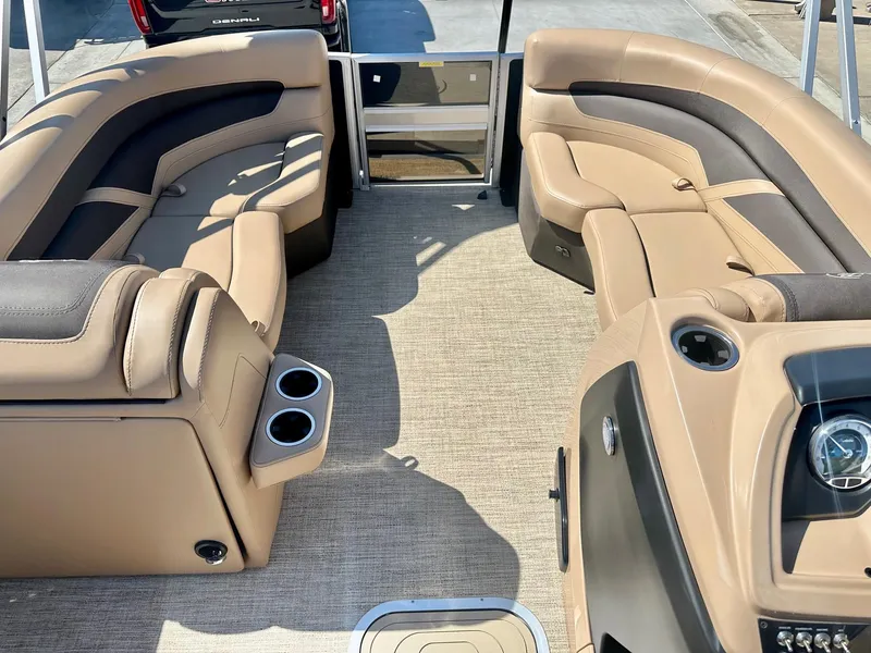 Slide: The Image of 2023 Barletta Cabrio 20Q boat interior with tan and black seating, cup holders, and dashboard. - 7
