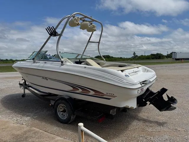 Slide: The Image of 1997 Sea Ray 210 Signature boat on trailer, parked outdoors under cloudy sky. - 3