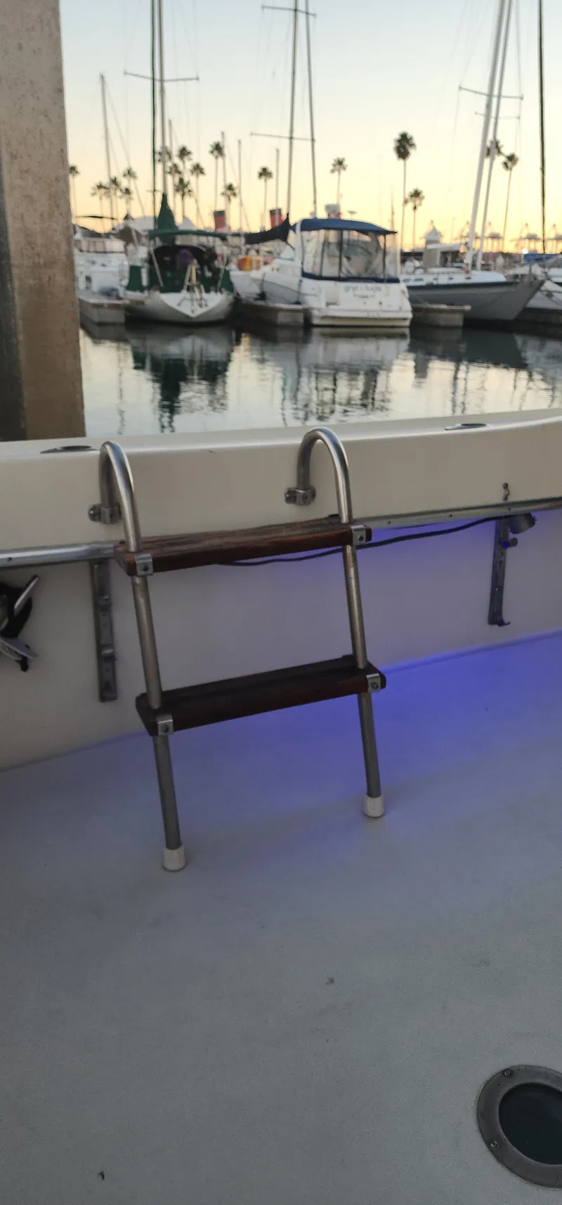 Slide: The Image of 1978 Hatteras Sportfish boat with ladder, docked at marina during sunset. - 16