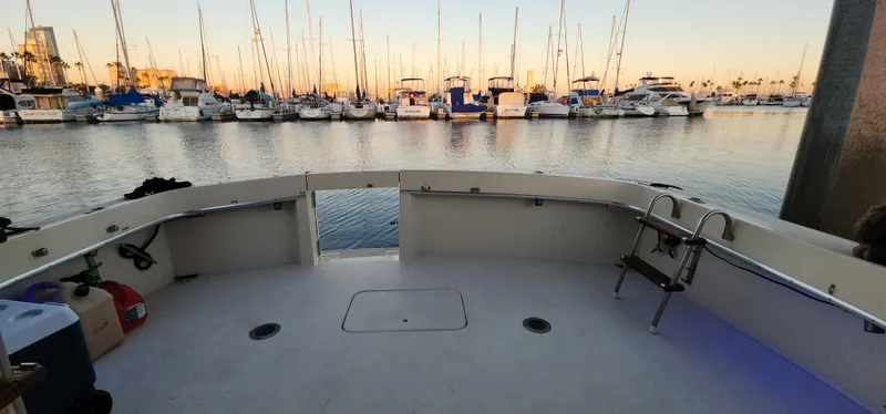 Slide: The Image of 1978 Hatteras Sportfish boat docked at marina with sailboats in background. - 24