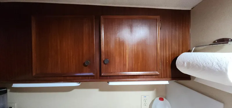 Slide: The Image of 1978 Hatteras Sportfish interior with wooden cabinets and paper towel holder. - 25