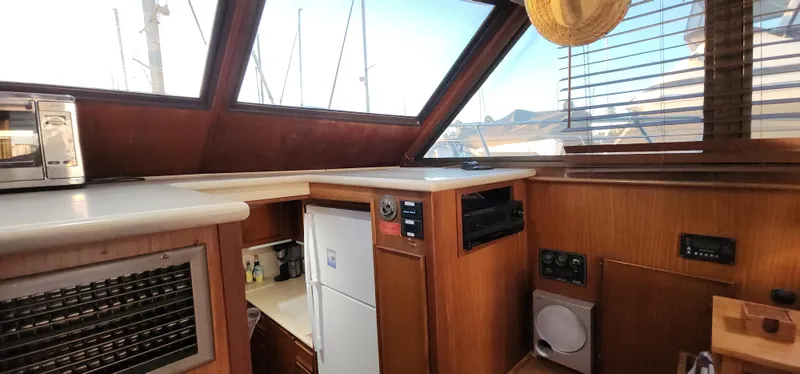 Slide: The Image of 1978 Hatteras Sportfish interior with wood paneling, appliances, and large windows. - 33