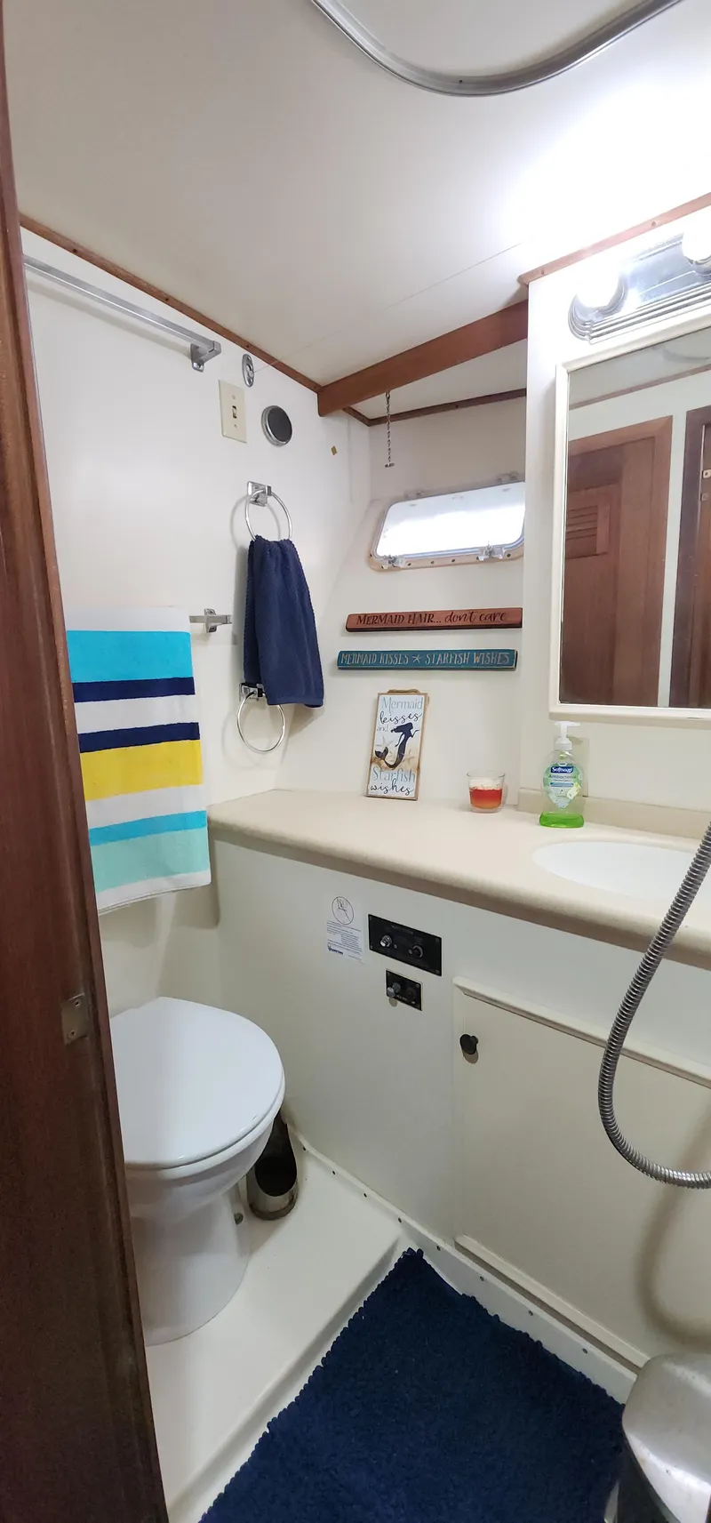 Slide: The Image of 1978 Hatteras Sportfish bathroom with toilet, sink, mirror, and colorful towels. - 38