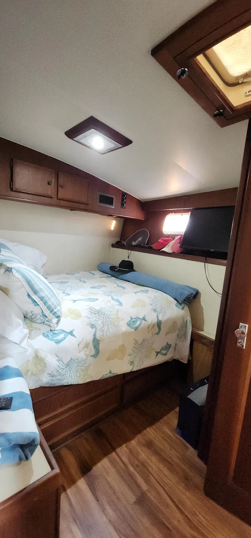 Slide: The Image of 1978 Hatteras Sportfish cabin interior with bed, wooden cabinets, and TV. - 41
