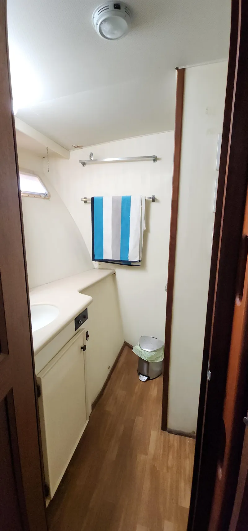 Slide: The Image of 1978 Hatteras Sportfish bathroom with wood flooring and striped towel. - 43