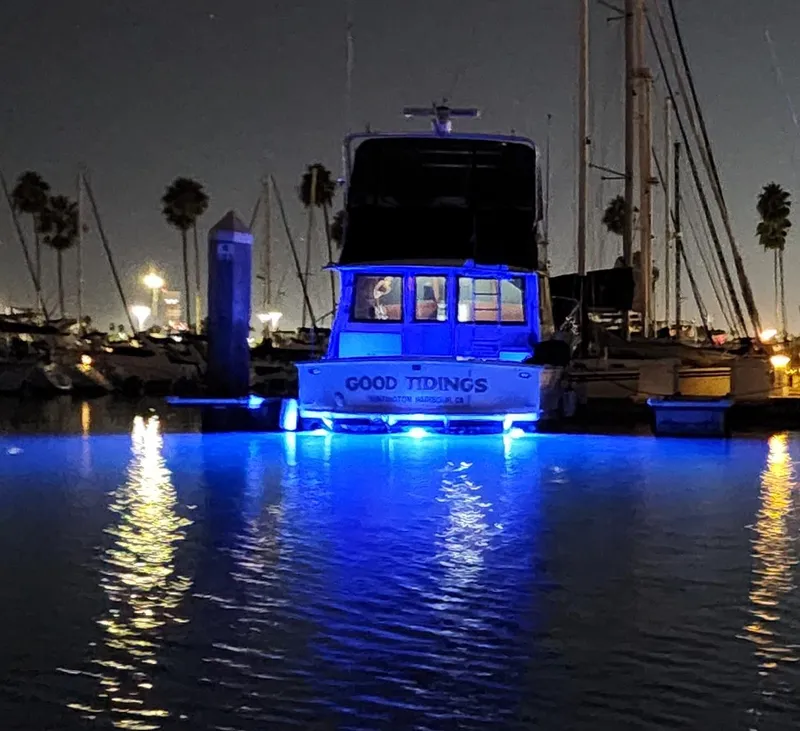 Slide: The Image of 1978 Hatteras Sportfish boat with blue lights at night in a marina. - 6